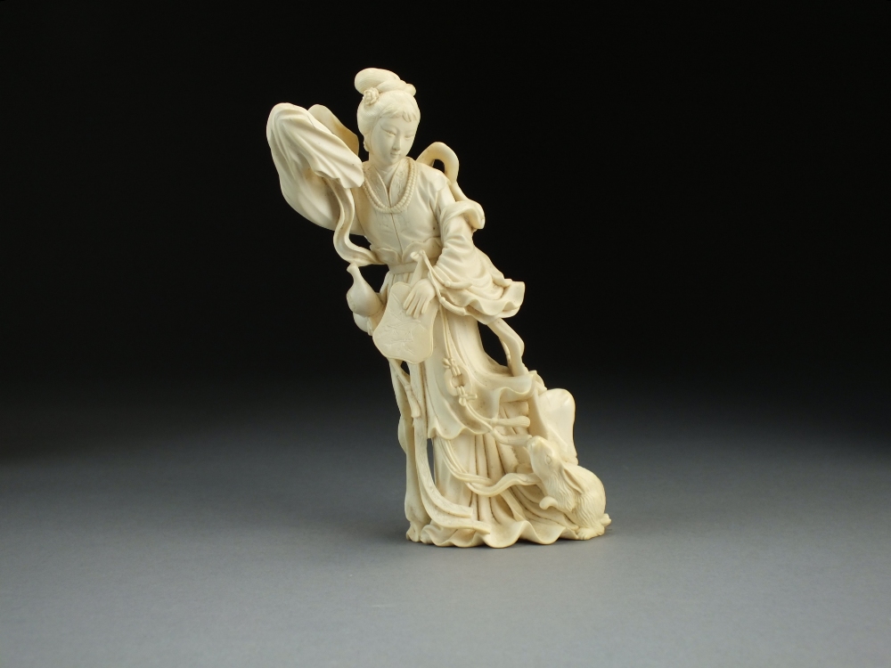 A Chinese ivory figure, late Qing Dynasty, modelled as a maiden in flowing robes and holding a fan,
