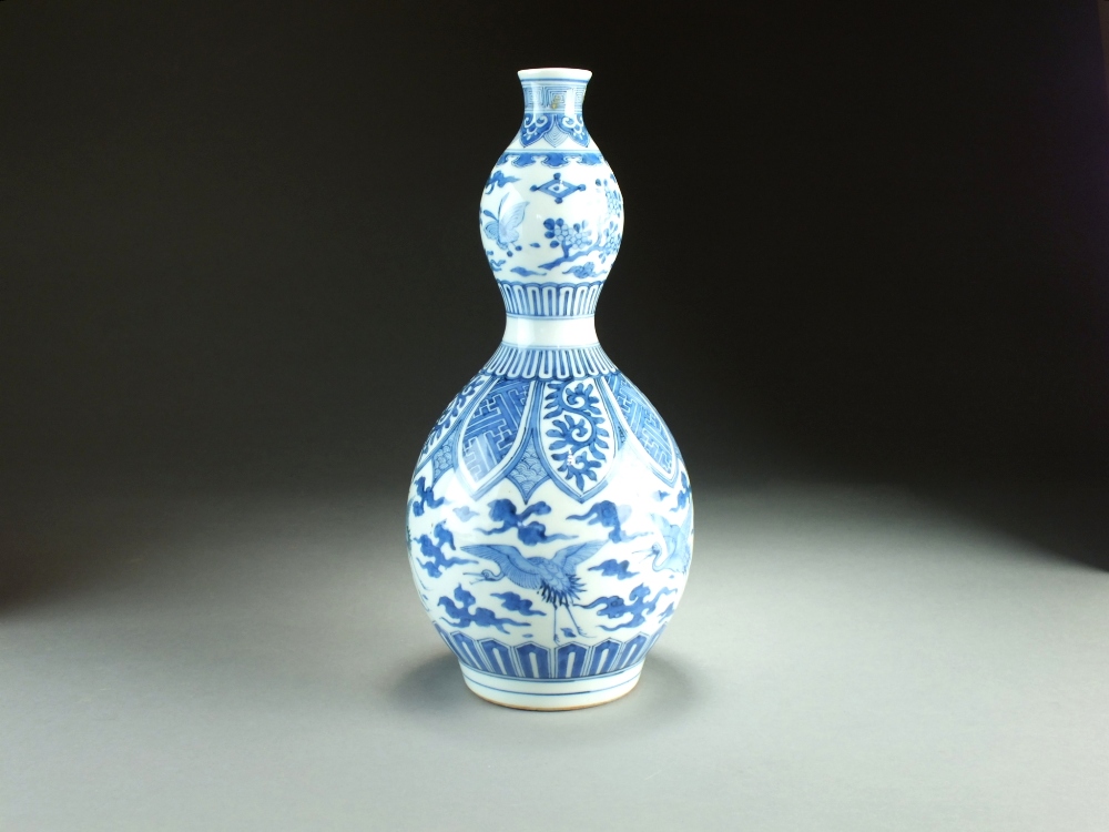 A Chinese blue and white double gourd vase, 19th Century, decorated with concentric bands of ruyi,