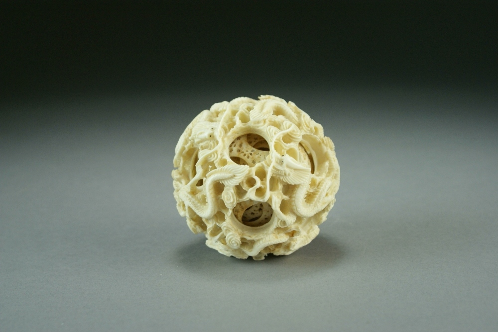 A Chinese Canton carved ivory puzzle ball, Qing Dynasty, worked with wrythen dragons amid clouds,