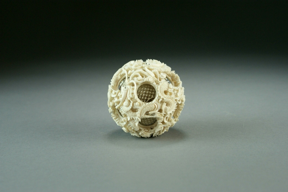 A Chinese Canton carved ivory puzzle ball, Qing Dynasty, worked with wrythen dragons amid clouds,