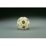 A Chinese Canton carved ivory puzzle ball, Qing Dynasty, worked with wrythen dragons amid clouds,