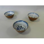 Three Chinese porcelain tea bowls from the Nanking cargo decorated with flowers and rocks by a