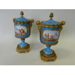 A pair of Sevres style ormolu mounted vases and covers painted in colours with scenes of workers