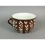 An amusing slip ware chamber pot the interior with chocolate brown mound/mask in the bottom with