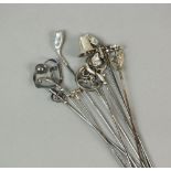 A collection of ten silver and white metal mounted hat pins,