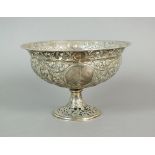 A continental silver pedestal comport, embossed and pierced with scroll, urn and floral decoration,