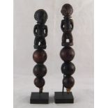 A pair of African carved figure and natural seed rattles, ht.28cm.