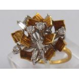 A yellow metal (tests 18 carat gold) round brilliant and baguette cut modernist diamond cluster