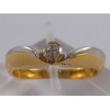 A two colour 18 carat gold diamond solitaire ring, size O, 5.6 gms.