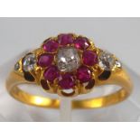 A yellow metal (tests 18 carat gold) old cushion cut diamond and ruby ring, size N ½, 3.7 gms.
