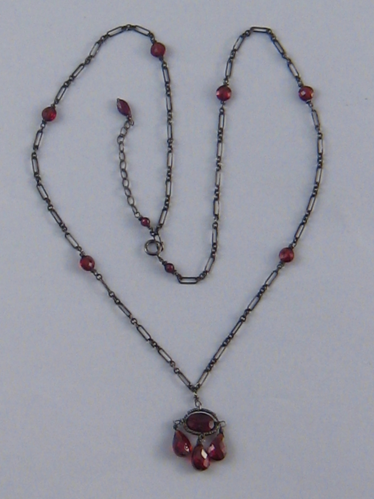 A silver and garnet necklace.