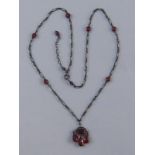 A silver and garnet necklace.