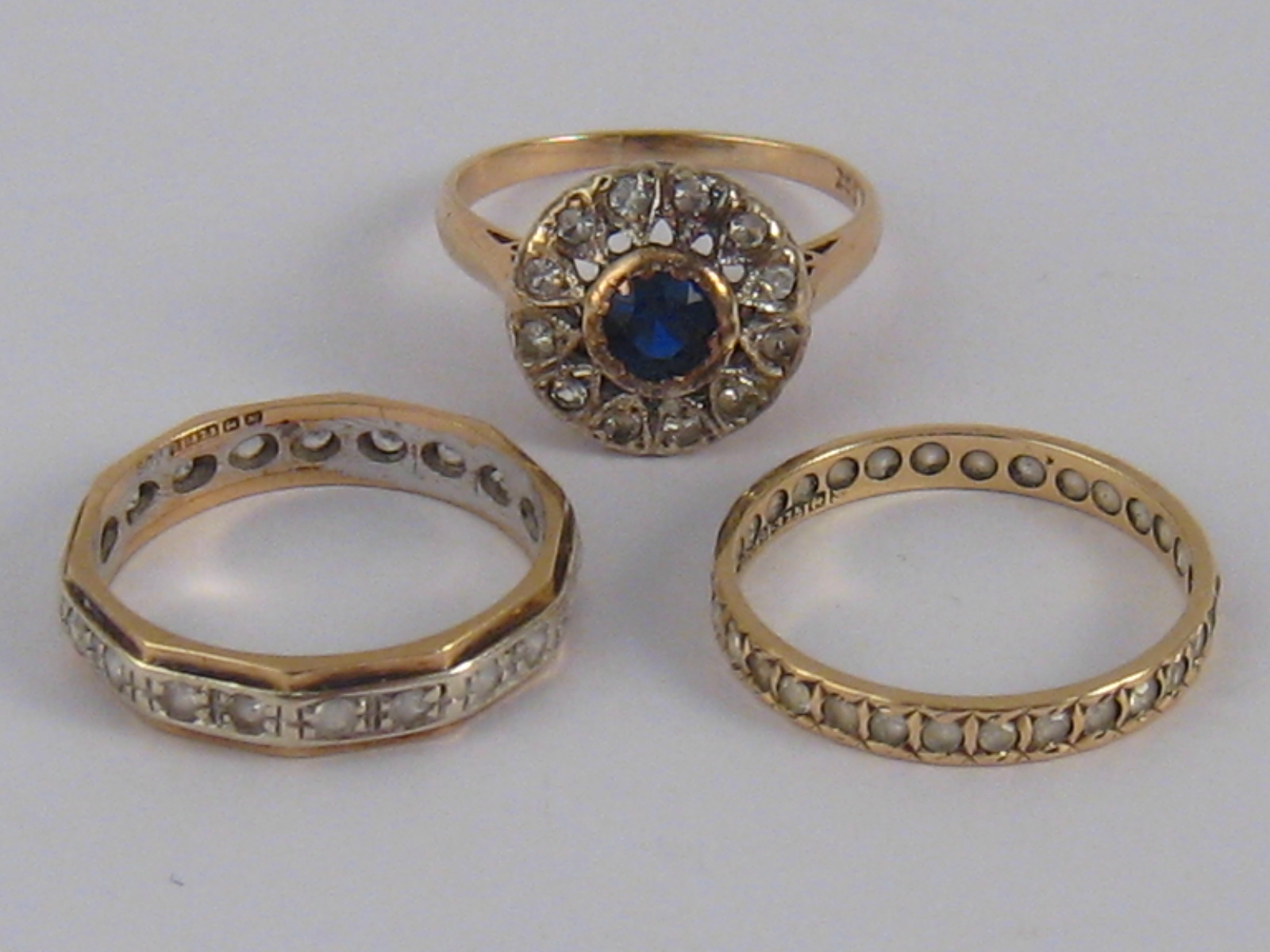 A mixed lot comprising two 9 carat gold rings and a yellow metal (tests 9 carat gold) ring,