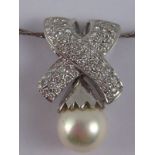 A white metal (tests 18 carat gold) cultured pearl and diamond pendant, chain marked 750,