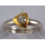 A two colour 18 carat gold diamond solitaire ring,