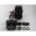 A Rolleicord camera, Zeiss tessar 1.35 lens, in ER case with lens hoods and filters.