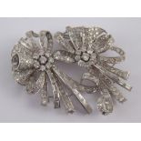 A white metal (tests platinum) diamond double clip brooch of floral design, the round brilliant,