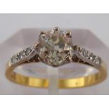 A yellow metal (tests 18 carat gold) diamond solitaire ring with diamond set shoulders,