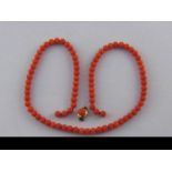 A coral bead necklace, with coral set gold clasp, in need of restringing, necklace approx 52cm long,