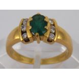 An 18 carat gold emerald and diamond ring, emerald approx 6 x 4mm, ring size K, 3.