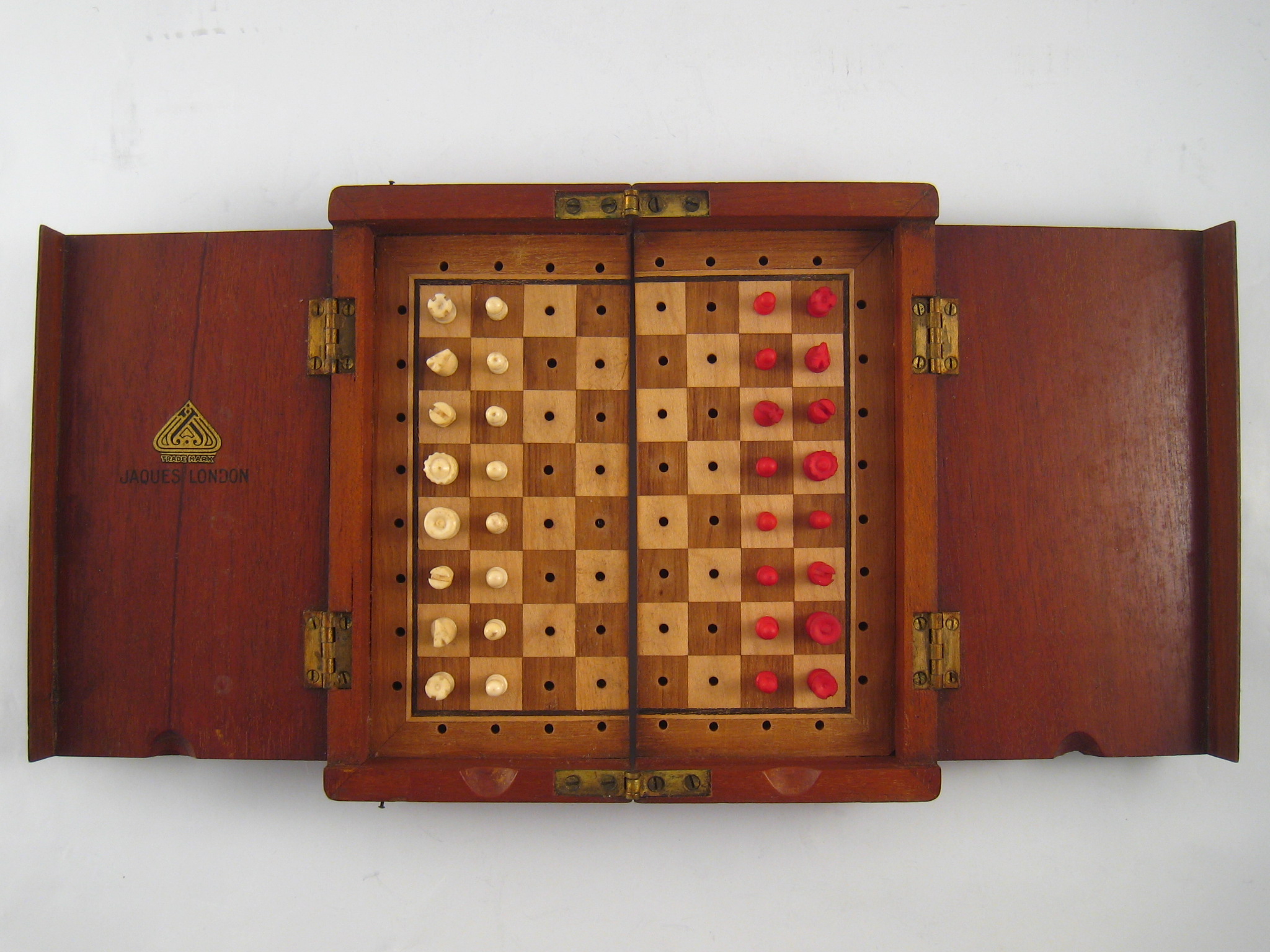 A mahogany folding chess set , the composition peg pieces on the wooden board with retaining covers.