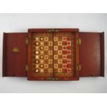 A mahogany folding chess set , the composition peg pieces on the wooden board with retaining covers.