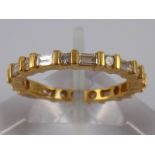 An 18 carat gold round brilliant and baguette cut diamond eternity ring, approx 2.