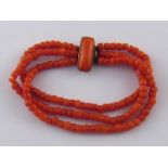 A three row coral bead bracelet, beads approx 4.2-4.8mm, with coral set clasp, approx 18cm long.