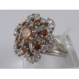 A white metal (tests 18 carat gold) fancy brown and white diamond ring,