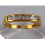 An 18 carat gold channel set princess cut diamond ring, size O, 3.5 gms.