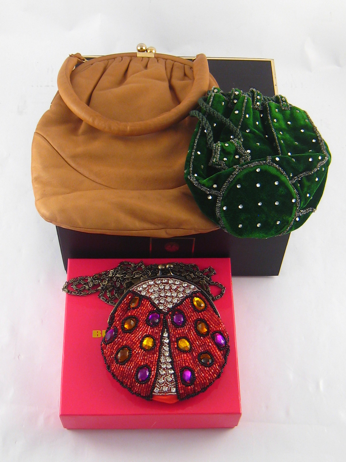 A Butler & Wilson beaded evening bag together with two vintage evening bags.