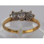 A yellow metal (tests 18 carat gold) three stone diamond ring, marked 18ct plat,