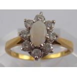 An 18 carat gold opal and diamond ring, opal approx 6 x 4mm, estimated diamond content approx 0.