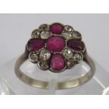 A white metal (tests 18 carat gold) ruby and old brilliant cut diamond cluster ring,
