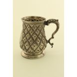 A Victorian silver mug in the historicismus style with leaf capped double scroll handle,