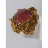 A yellow metal (tests 18 carat gold) naturalistic cabochon pink tourmaline and diamond ring,