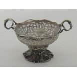 A Victorian pierced silver sugar bowl with scrolling cast handles and foot,