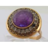 A yellow metal (tests 18 carat gold) amethyst paste ring, marked K18, lacking one clear paste stone,