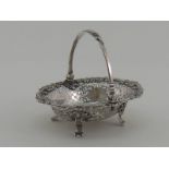 A George II silver swing handled sweetmeats basket with cast rim,