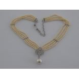 A four row cultured pearl necklace with a white metal (tests 18 carat gold) clasp and diamond set