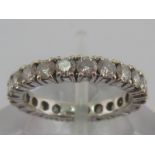 A white metal (tests 18 carat gold) diamond eternity ring,