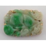 A Chinese carved jadeite brooch with a yellow metal (tests 14 carat gold) frame, approx 44 x 31mm,