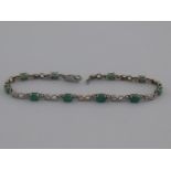 A white metal emerald and diamond bracelet, marked 750, approx 19cm long, 6.4 gms.