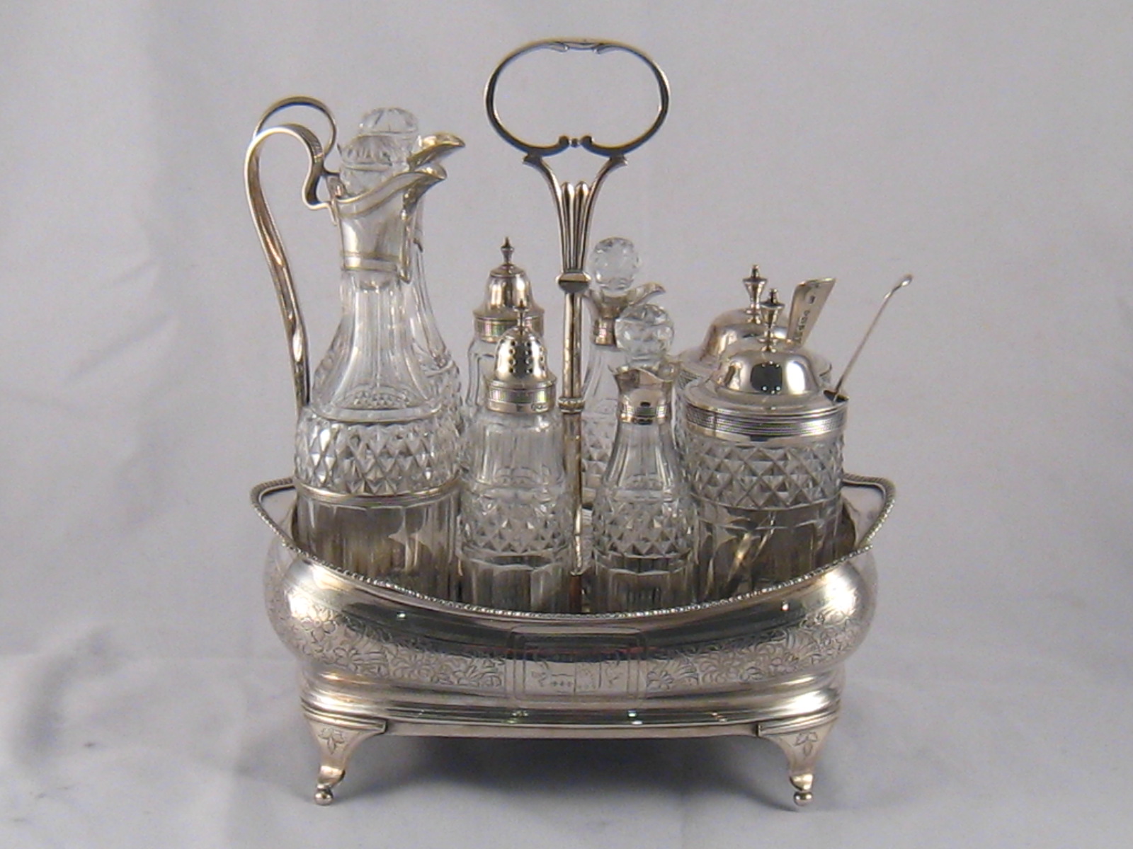 A George III silver eight bottle cruet set , the frame with gadrooned edge, all original bottles,