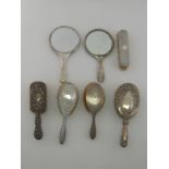 Two silver backed hand mirrors, together with five silver backed brushes.