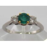 A Tiffany emerald and diamond three stone ring, the central round cut .