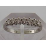 A platinum and diamond half eternity ring, the seven brilliants totalling approx. .