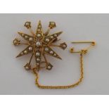 A late Victorian 15 carat yellow gold and seed pearl star burst brooch, stamped verso '15ct',