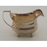 A George III silver barge shaped cream jug on four ball feet by Godbehere Wigan and Bult (mark