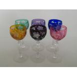 A set of six wine glasses with slice cut stems, the bowls each flashed with a different colour,